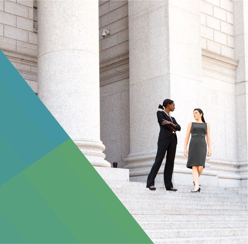Two female lawyers on the steps of a courthouse.