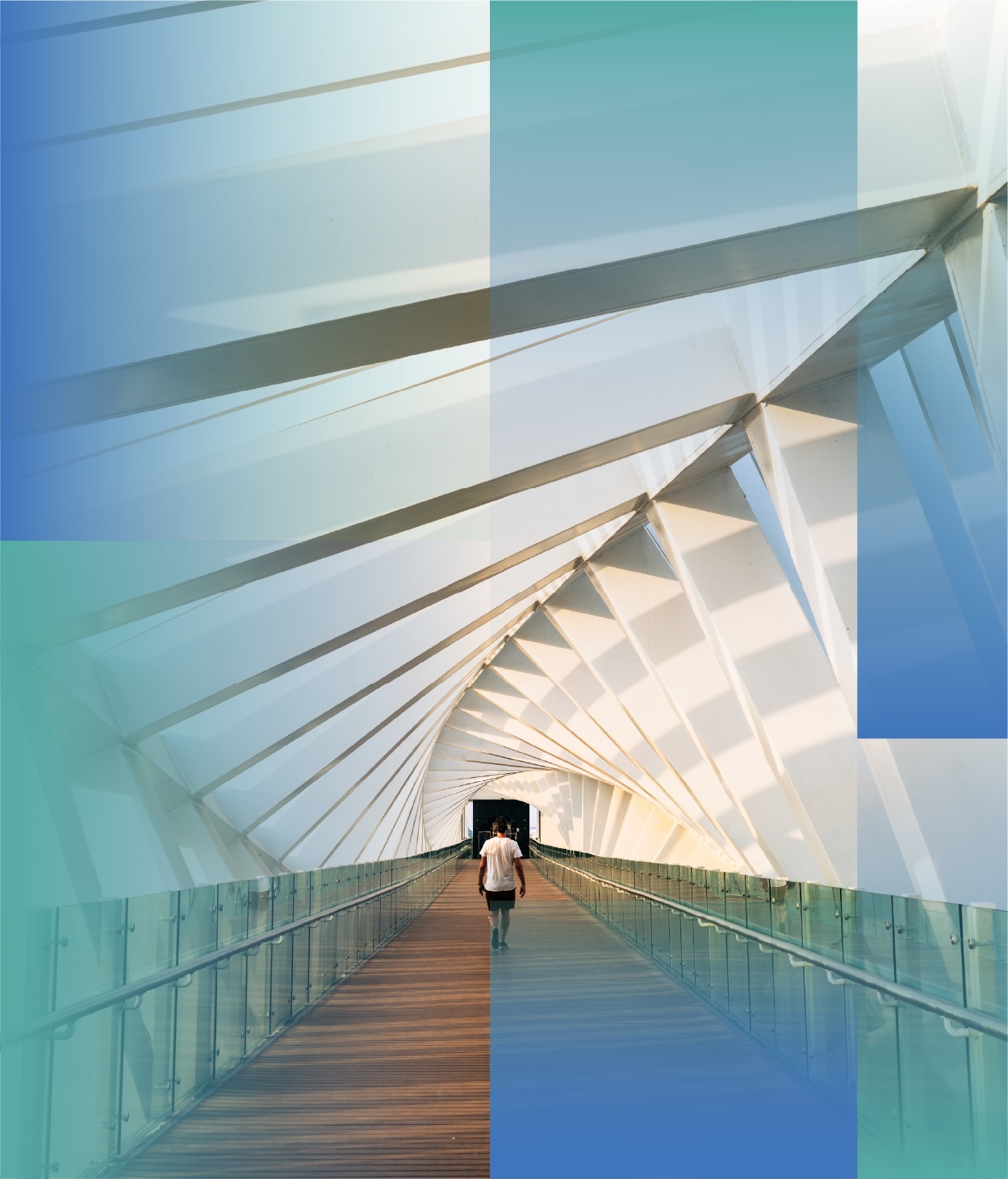 A person walking alone across a long, enclosed pedestrian bridge with white geometric beams and glass railings, illuminated by natural light.