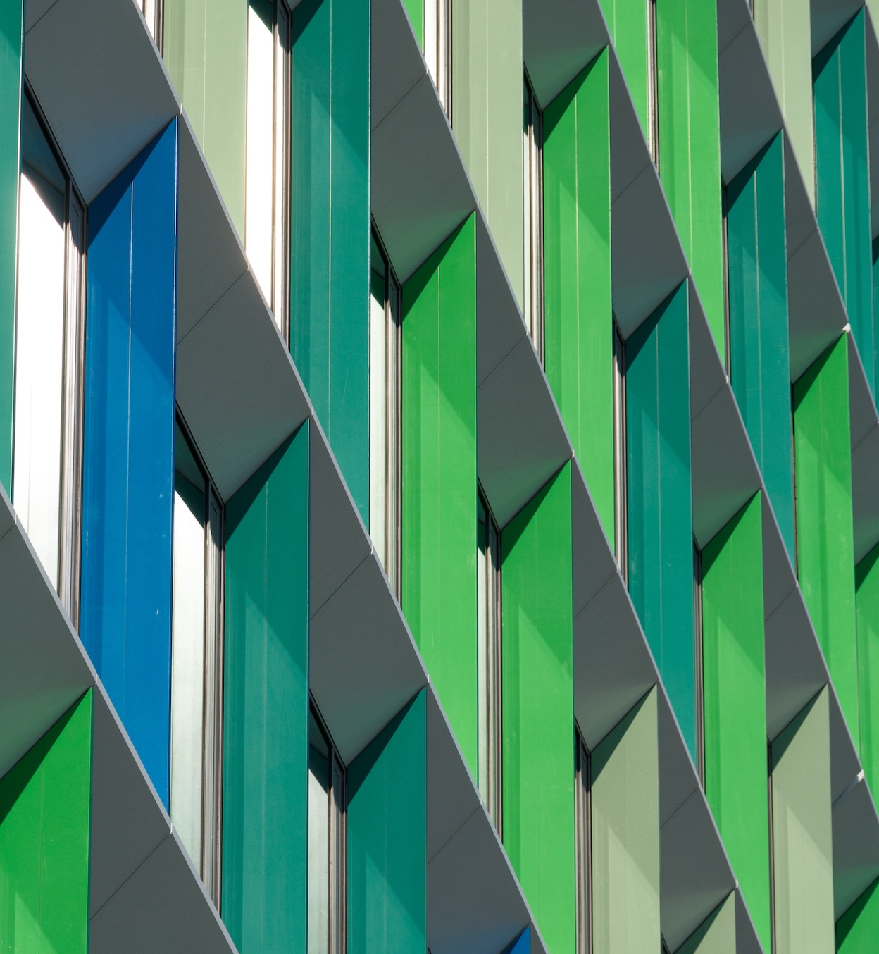 Building façade with green and blue windows.